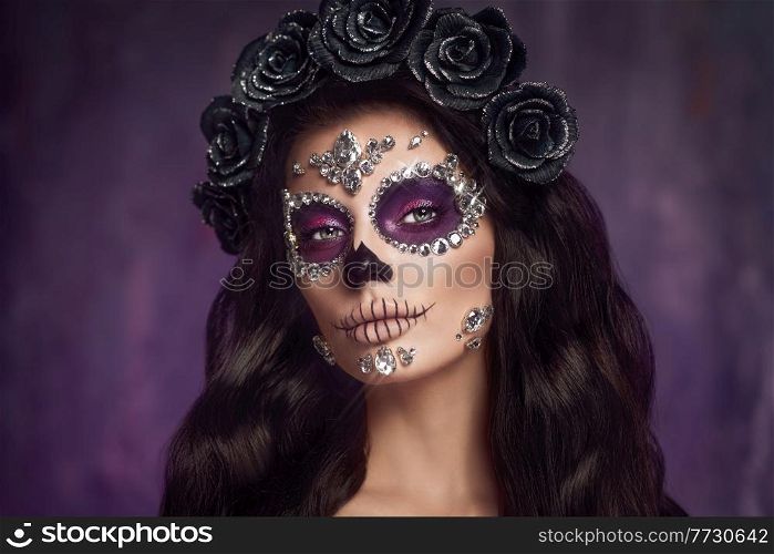 Portrait of a woman with sugar skull makeup over purple background. Halloween costume and make-up. Portrait of Calavera Catrina