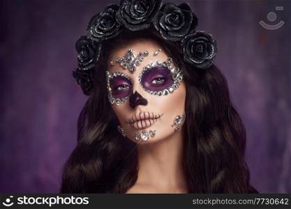 Portrait of a woman with sugar skull makeup over purple background. Halloween costume and make-up. Portrait of Calavera Catrina