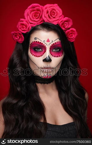 Portrait of a woman with sugar skull makeup over red background. Halloween costume and make-up. Portrait of Calavera Catrina