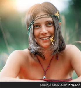 Portrait of a Woodstock Hippie style girl. With flower in the mouth. deliberately vintage photograph