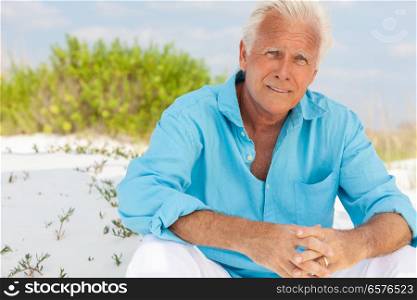 Portrait of a worried concerned thoughtful attractive handsome senior man sitting down outside on a beach and smiling. Portrait of Attractive Handsome Senior Man on Beach