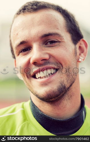 Portrait of a young active man smiling during sport training, exercise. Outdoor activity, healthy workout. Authentic