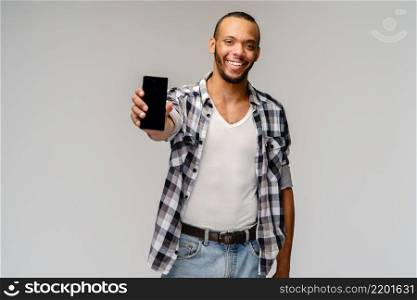 Portrait of a young african american man holding mobile cell phone.. Portrait of a young african american man holding mobile cell phone