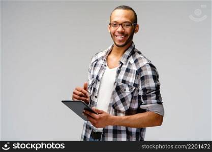 Portrait of a young african american man wearing green t-shirt holding tablet pc pad.. Portrait of a young african american man wearing green t-shirt holding tablet pc pad