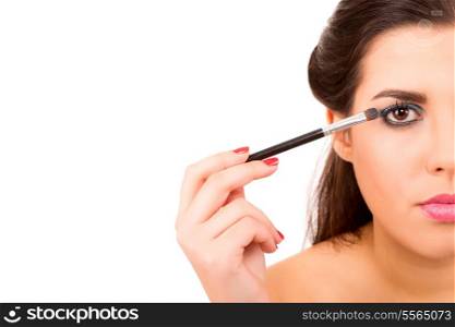 Portrait of a young and beautiful makeup artist with brushes