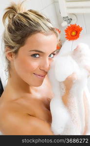 portrait of a young and cute girl in bathtub with face between foam