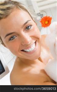 portrait of a young and cute girl in bathtub with foam and smiling