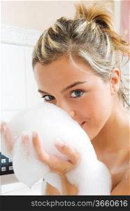 portrait of a young and cute girl in bathtub with foam near her face