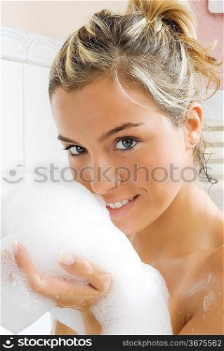 portrait of a young and cute girl in bathtub with foam near her face