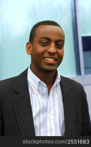 Portrait of a young attractive businessman next to a corporate building