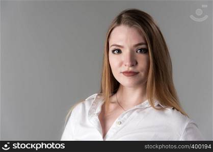 Portrait of a young attractive woman with blond hair on a neutral gray background. Close up.. Portrait of a young attractive woman with blond hair on a neutral gray background.