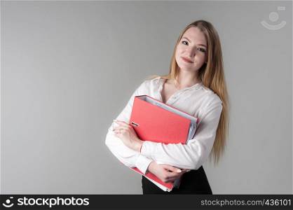 Portrait of a young attractive woman with blond hair on a neutral gray background. Red folder in hand.. Portrait of a young attractive woman with blond hair on a neutral gray background.