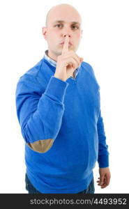 portrait of a young bald man making a shushing gesture with his finger, isolated on a white studio background.