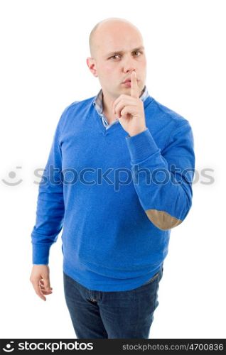 portrait of a young bald man making a shushing gesture with his finger, isolated on a white studio background.