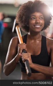 portrait of a young beautiful African American woman after training with a sledgehammer and tractor tire