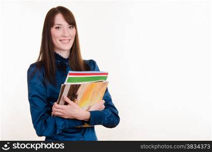 Portrait of a young beautiful girl in a strict office clothes and magazines in the hands of
