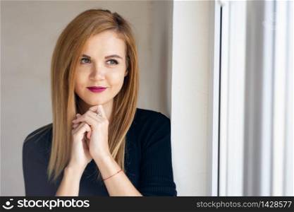Portrait of a young beautiful girl near a window with natural lighting