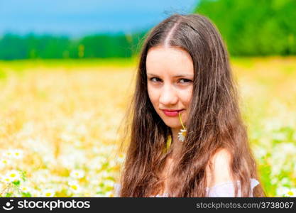 Portrait of a young beautiful girl with daisy flower