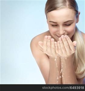 Portrait of a young beautiful woman cleaning her face with fresh water, morning freshness, removing makeup, skin care routine, health and beauty concept. Perfect skin