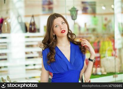 Portrait of a young beautiful woman on the background showcases a shoe store