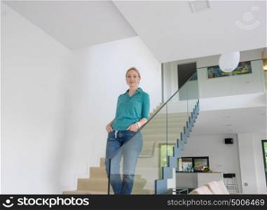 portrait of a young beautiful woman on the stairs in her luxurious home