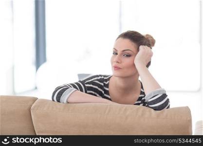 portrait of a young beautiful woman sitting on the sofa at home