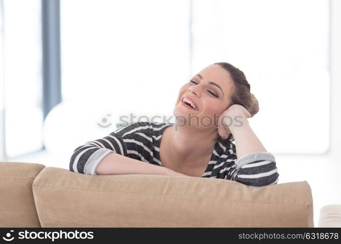 portrait of a young beautiful woman sitting on the sofa at home