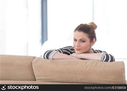portrait of a young beautiful woman sitting on the sofa at home