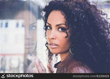Portrait of a young black woman, afro hairstyle, in urban background