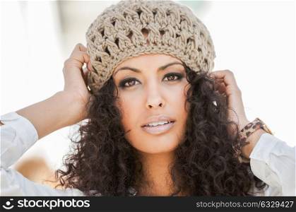 Portrait of a young black woman, afro hairstyle, in urban background, girl wearing wool cap