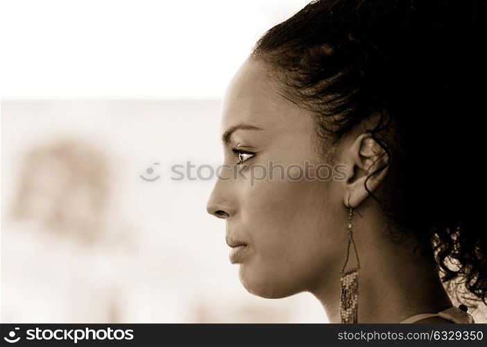 Portrait of a young black woman profile, model of fashion, with pink dress and earrings. Afro hairstyle
