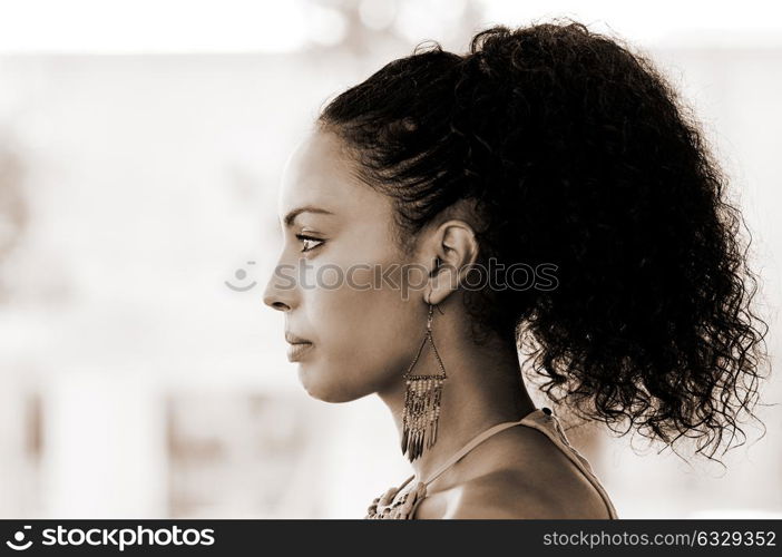 Portrait of a young black woman profile, model of fashion, with pink dress and earrings. Afro hairstyle
