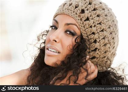 Portrait of a young black woman smiling with braces . Girl wearing wool cap.