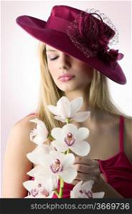 portrait of a young blond woman with red hat and an orchid