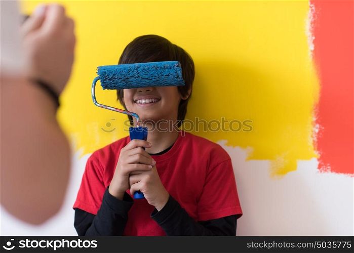 Portrait of a young boy painter with paint roller over the eyes