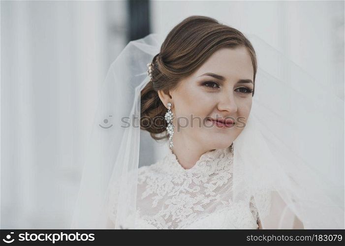 Portrait of a young bride about the white columns.. Portrait of a girl in a white dress and veil around the columns 4026.