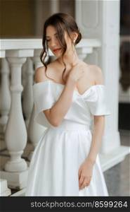 portrait of a young bride girl in a short white dress on a rainy day