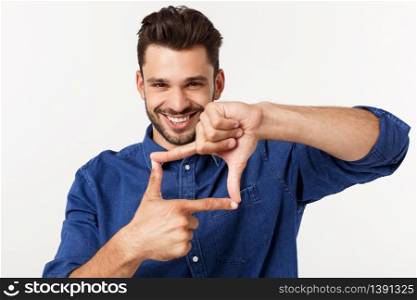 portrait of a young business man making a frame out of his fingers and smiling through it to the camera, on white. portrait of a young business man making a frame out of his fingers and smiling through it to the camera, on white.