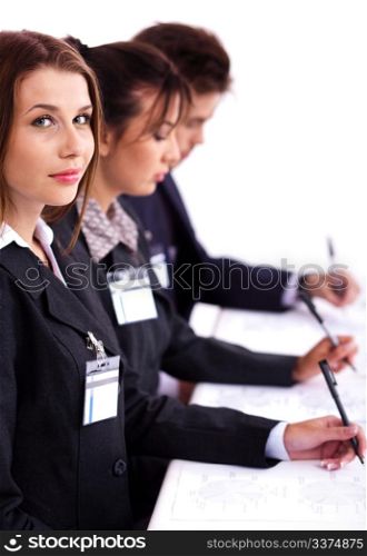 Portrait of a young business woman sitting at a meeting amidst her colleagues