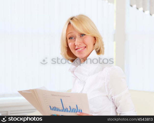 portrait of a young business woman with papers in the offcie