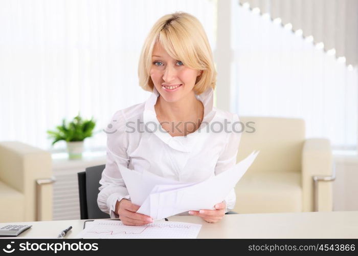 portrait of a young business woman with papers in the offcie