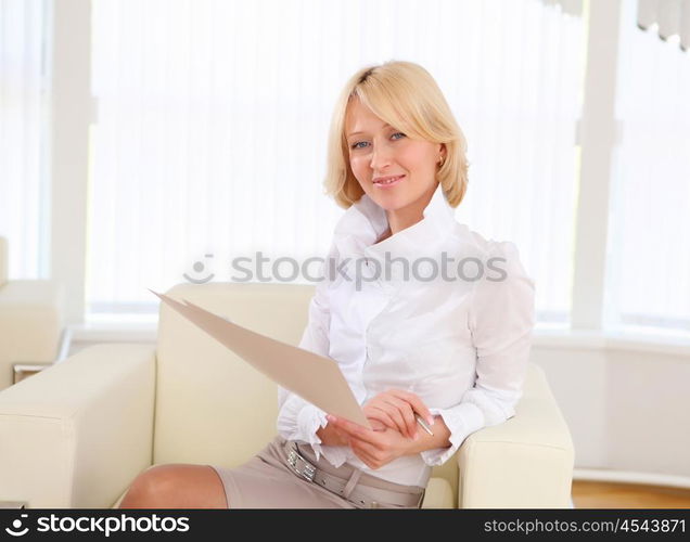 portrait of a young business woman with papers in the offcie