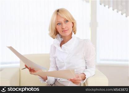 portrait of a young business woman with papers in the offcie