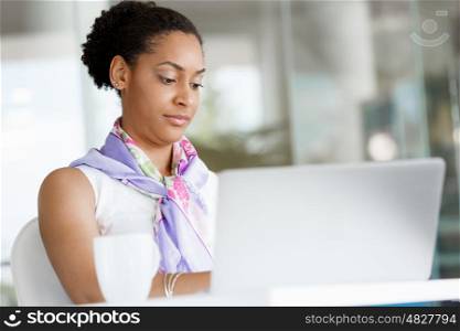 Portrait of a young business woman working on a laptop in a office