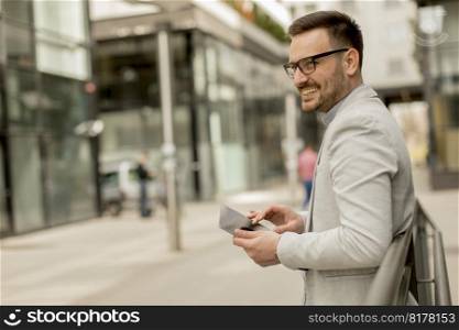 Portrait of a young businessman holding digital tablet outdoor in urban enviroment