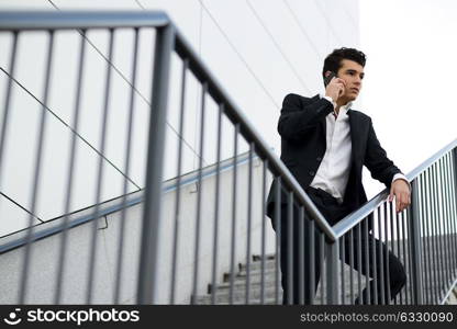 Portrait of a young businessman in an office building talking on the phone