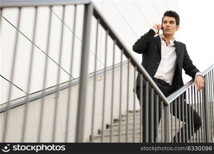 Portrait of a young businessman in an office building talking on the phone