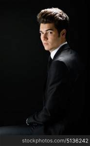 Portrait of a young businessman, isolated on black background