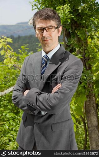 portrait of a young businessman thinking with glasses, outdoors