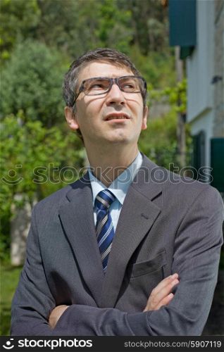portrait of a young businessman thinking with glasses, outdoors